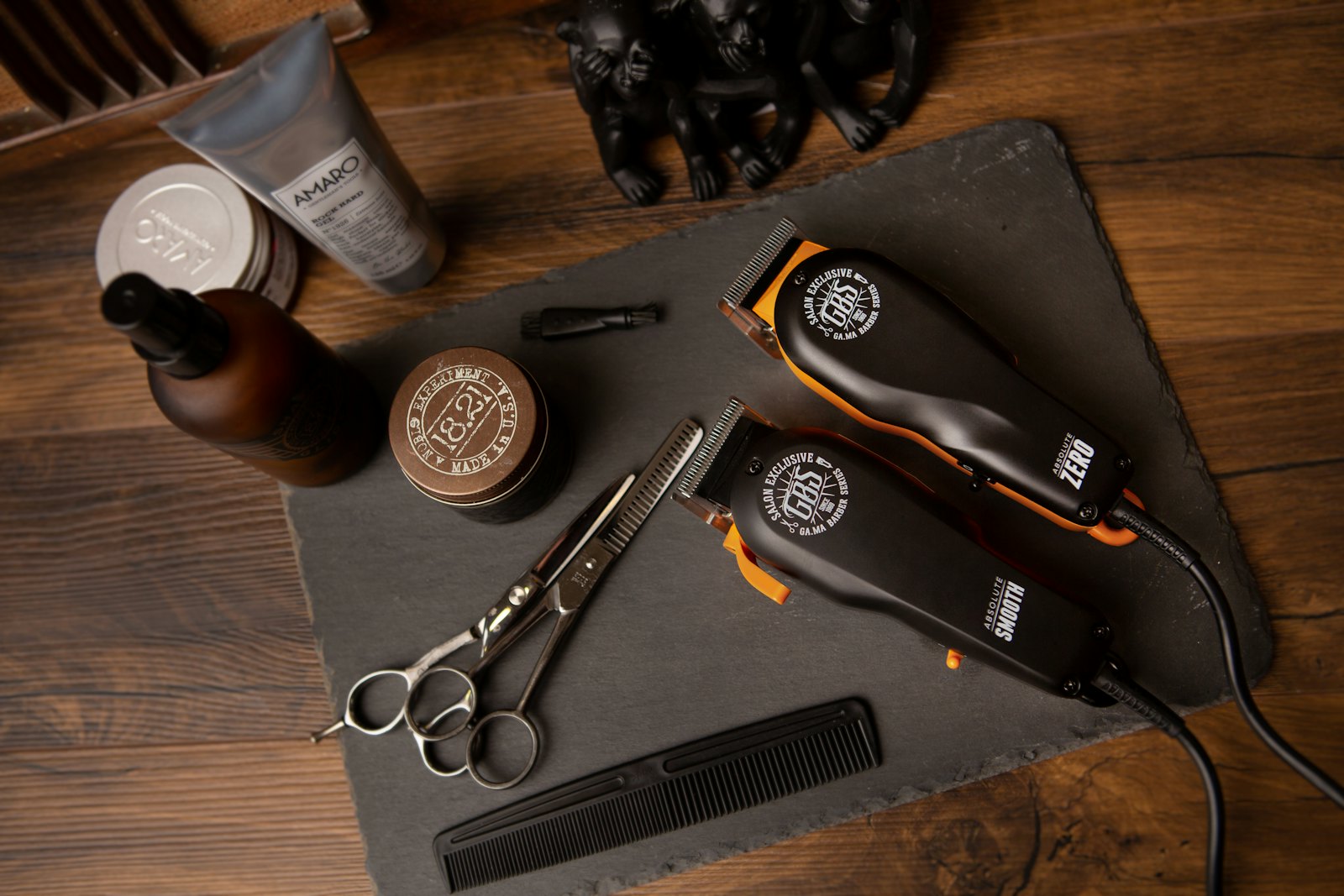 Gunting, clipper, sisir dan pomade di atas meja kayu