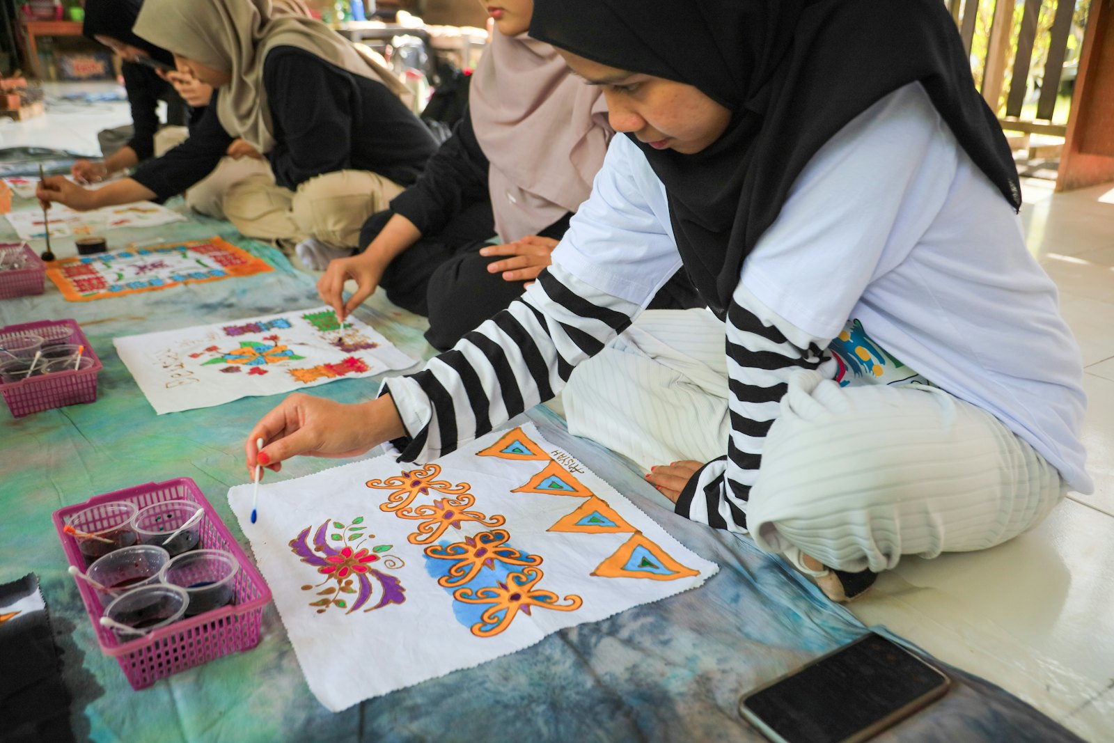 Para perajin perempuan menggambar pola batik di workshop