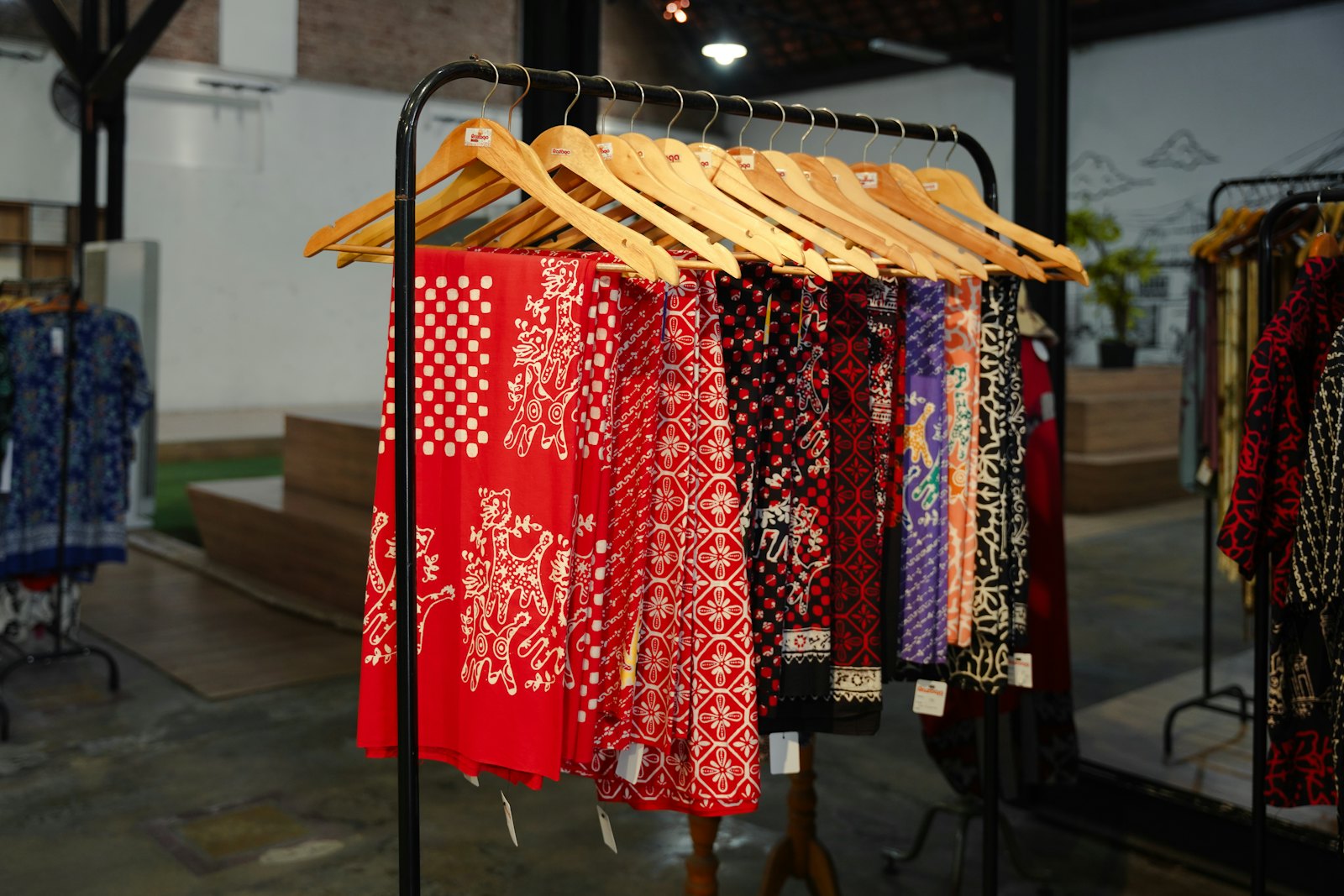 Rak kain batik merah bermotif di butik Rumah Batik Sekar
