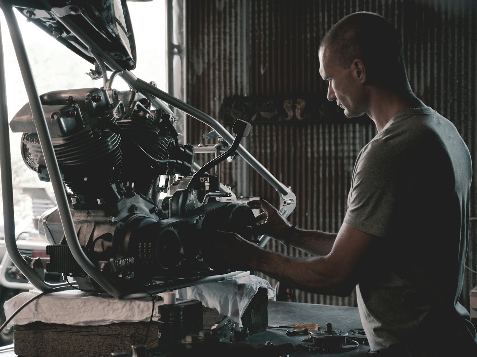 Mekanik memeriksa mesin motor di meja kerja