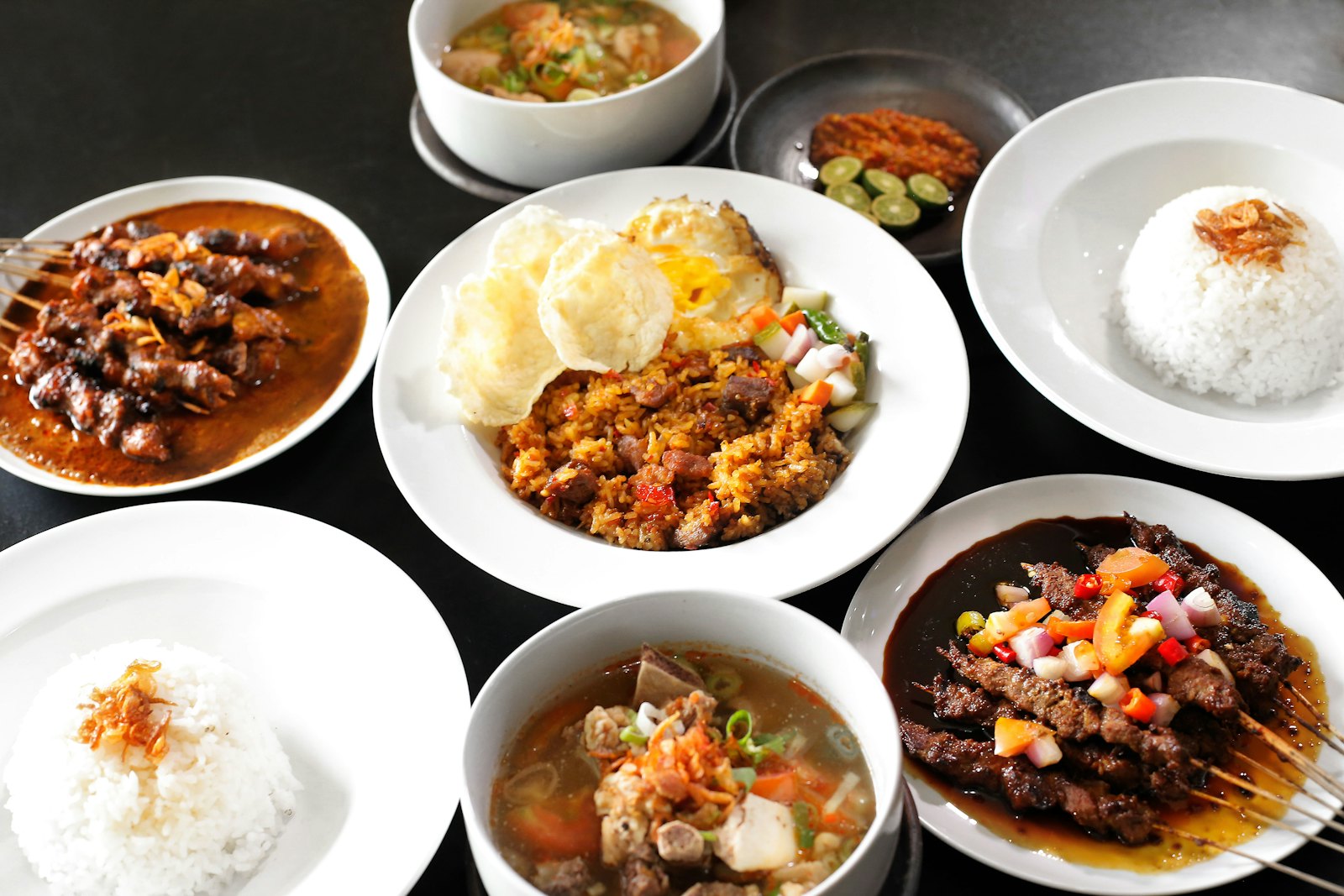 Meja penuh hidangan khas Makassar: sate, sop, nasi, dan lauk