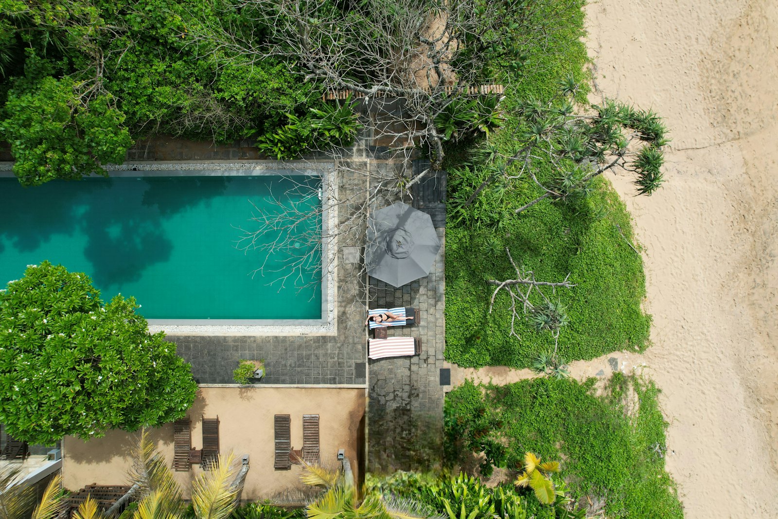 Foto udara kolam renang resort di samping pantai berpasir putih